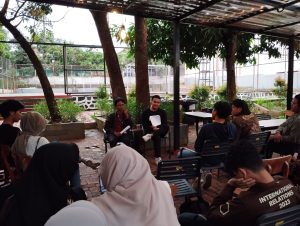 Kedua pembicara bersama audiens dalam lingkaran audiens (Sumber foto: Taufiqurrahman Alfarisi)